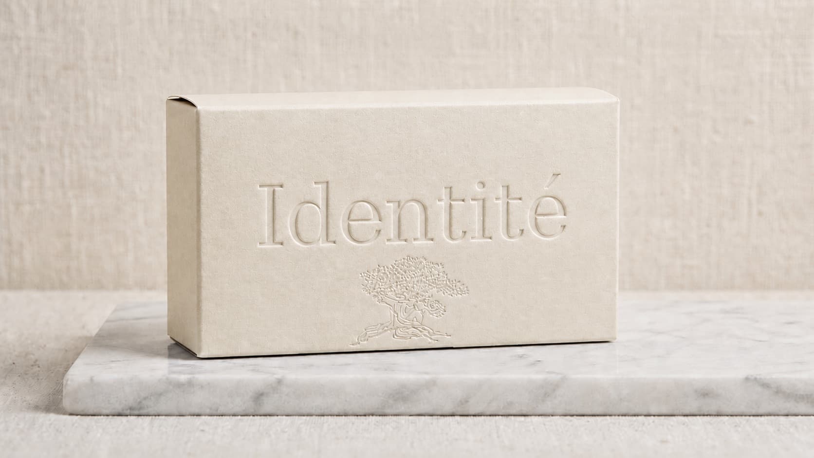 Embossed Identité packaging box with tree mark, on marble